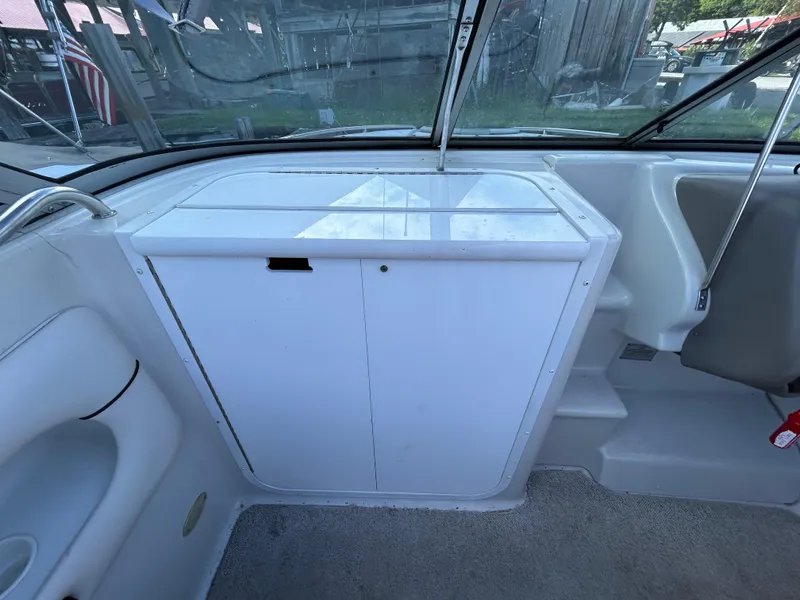 Slide: The Image of Interior view of 2000 Crownline 266 CCR boat, featuring a white storage cabinet. - 19