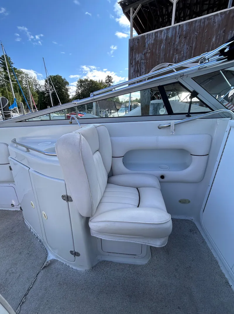 Slide: The Image of 2000 Crownline 266 CCR boat interior with white seating and clear skies. - 20
