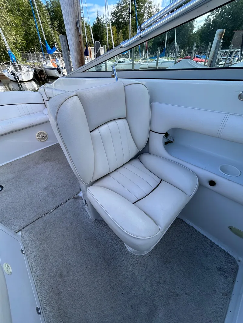 Slide: The Image of Crownline 266 CCR 2000 boat interior with white leather seat and marina background. - 22