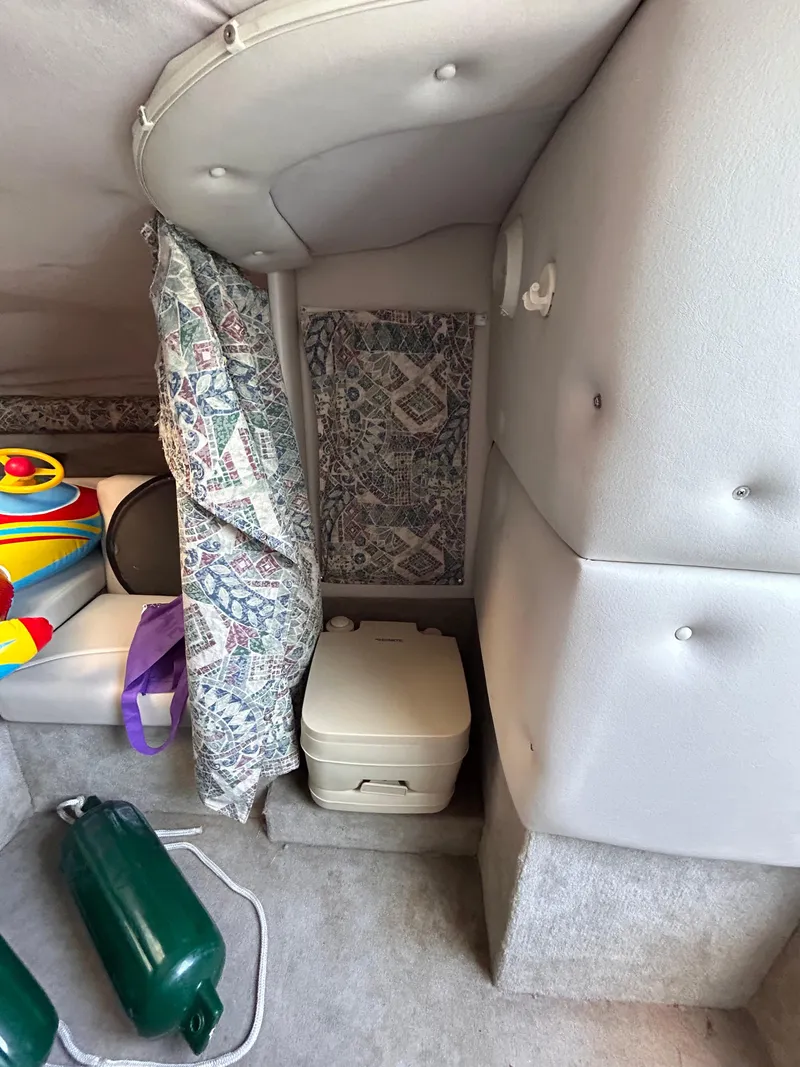 Slide: The Image of Interior of 2000 Crownline 266 CCR boat with portable toilet and colorful accessories. - 25