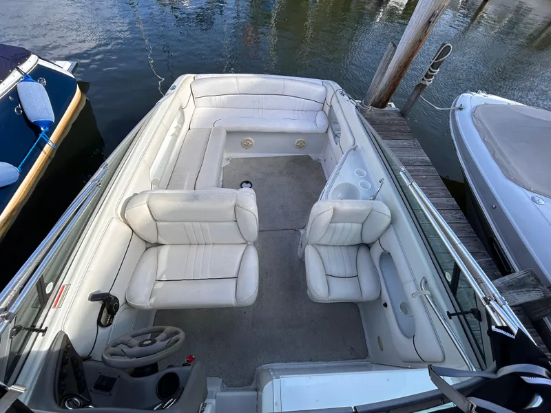 Slide: The Image of 2000 Crownline 266 CCR boat interior with white seating, docked at marina. - 3