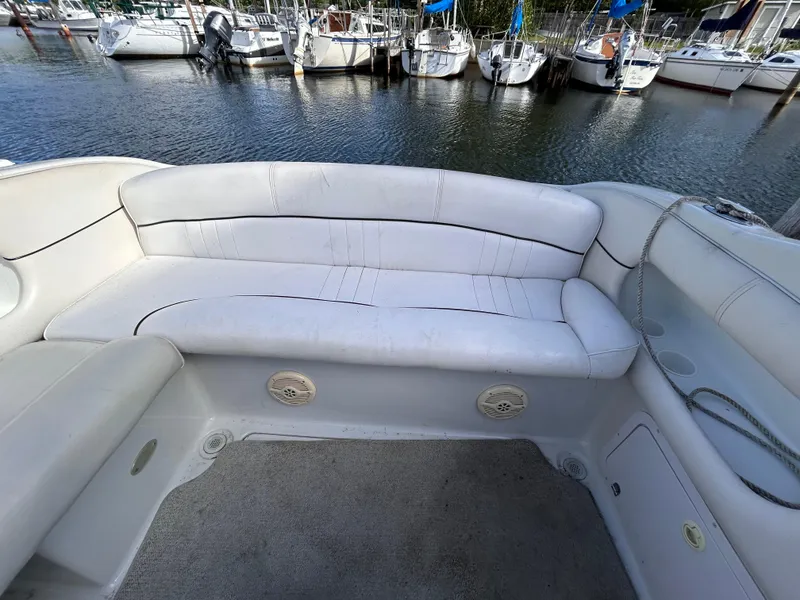Slide: The Image of Crownline 266 CCR 2000 boat interior with white seating, docked at marina. - 5