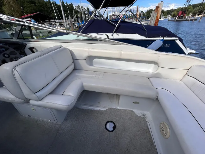 Slide: The Image of 2000 Crownline 266 CCR boat interior with white seating, docked at marina. - 6