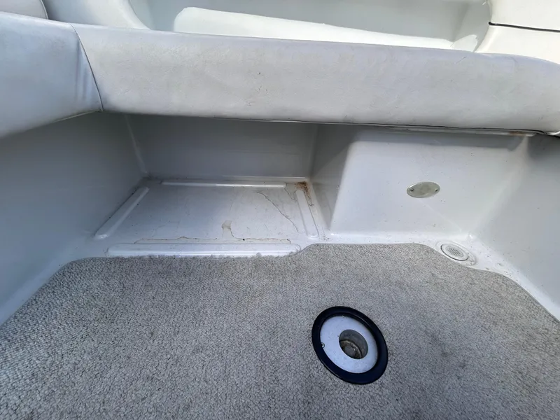 Slide: The Image of Interior view of 2000 Crownline 266 CCR boat, featuring carpeted flooring and seating area. - 7