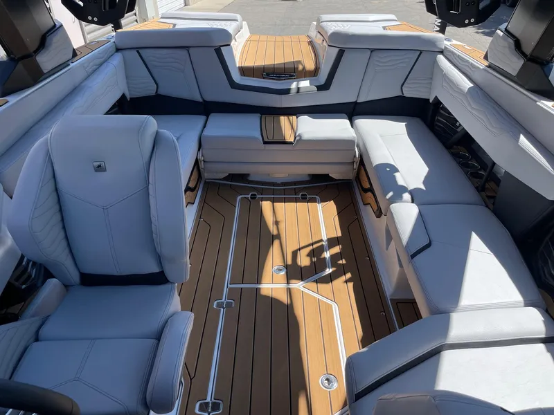Slide: The Image of 2025 Nautique G23 boat interior with luxurious seating and teak flooring. - 12