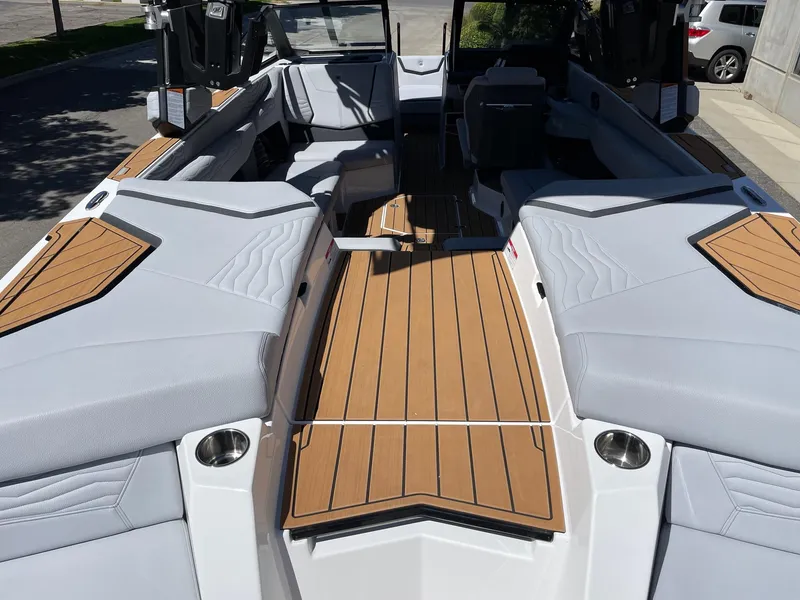 Slide: The Image of 2025 Nautique G23 boat interior with sleek gray seating and wooden deck accents. - 4