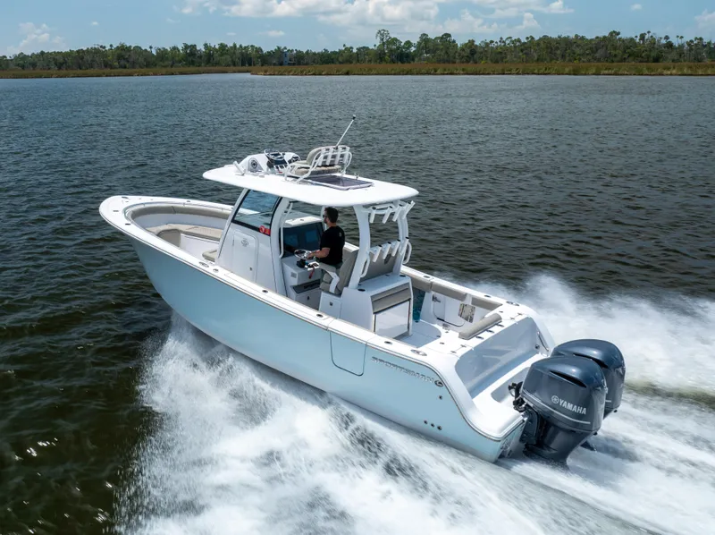 The Image of 2021 Sportsman Open 302 Center Console boat cruising on a lake. - 0
