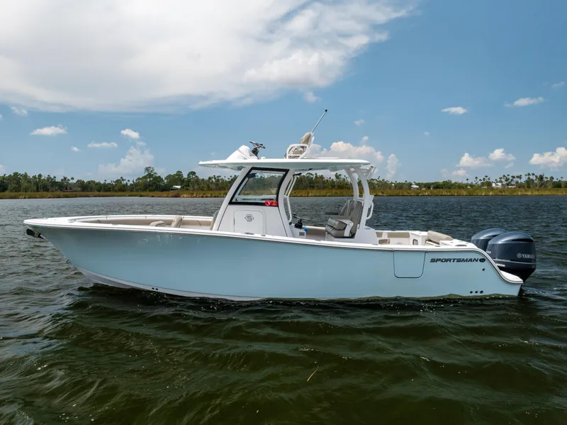 Slide: The Image of 2021 Sportsman Open 302 Center Console boat on calm water under a clear sky. - 11