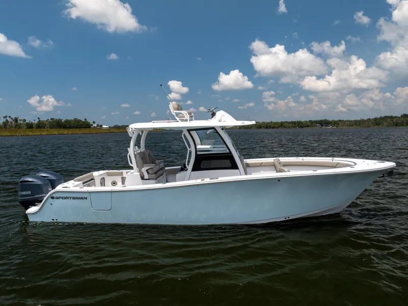 Slide: The Image of 2021 Sportsman Open 302 Center Console boat on calm water under blue sky. - 17
