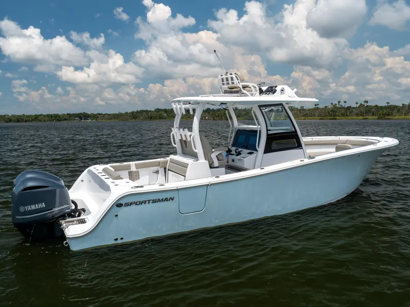 Slide: The Image of 2021 Sportsman Open 302 Center Console boat on calm water under blue sky. - 18