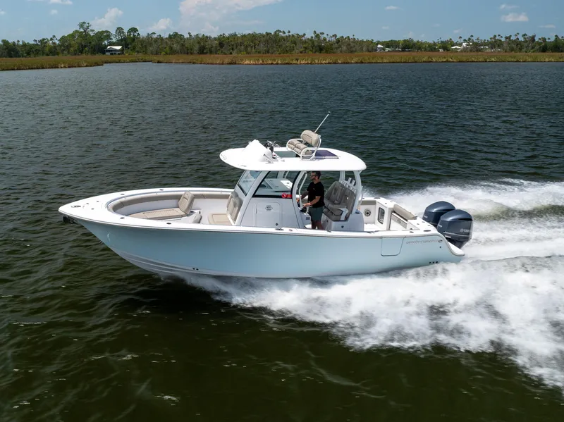 Slide: The Image of 2021 Sportsman Open 302 Center Console boat cruising on a lake. - 2