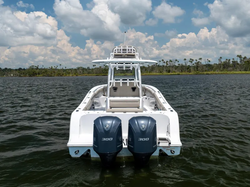 Slide: The Image of 2021 Sportsman Open 302 Center Console boat on water, twin engines, clear sky. - 21