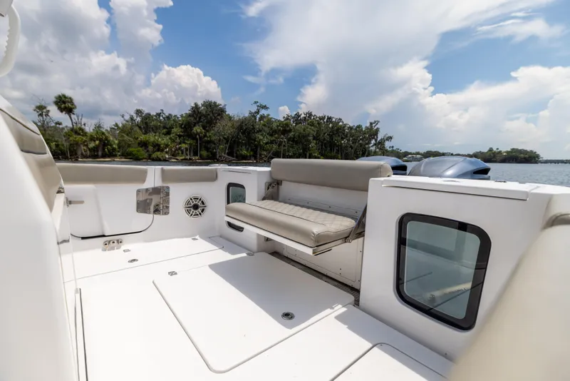 Slide: The Image of 2021 Sportsman Open 302 Center Console boat interior with seating, under a partly cloudy sky. - 25