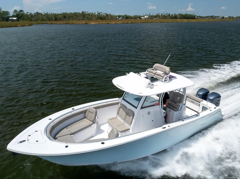 Slide: The Image of 2021 Sportsman Open 302 Center Console boat cruising on a lake. - 3