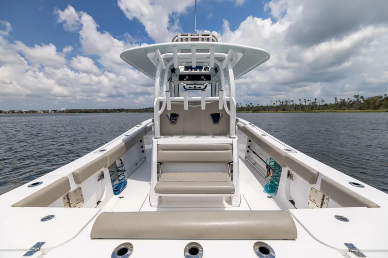 Slide: The Image of 2021 Sportsman Open 302 Center Console boat on calm water under a cloudy sky. - 30