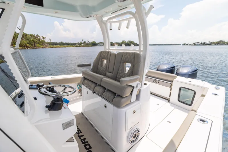 Slide: The Image of 2021 Sportsman Open 302 Center Console boat interior with dual engines on a calm lake. - 35
