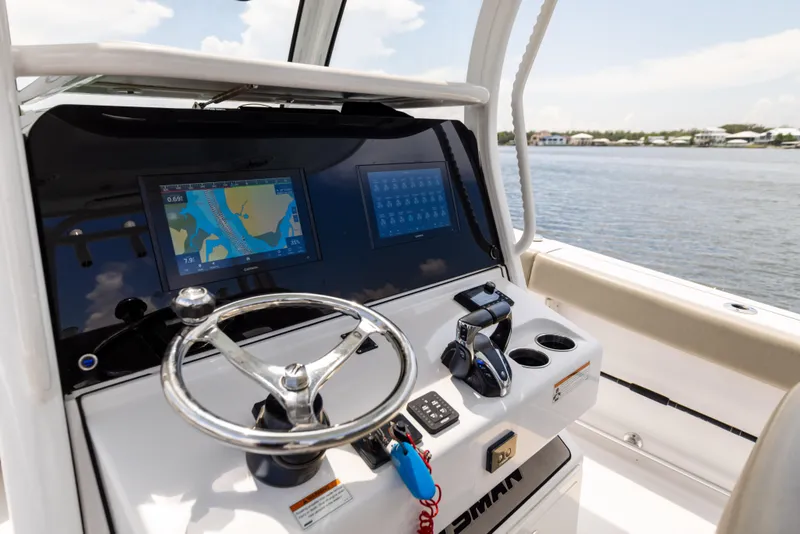Slide: The Image of 2021 Sportsman Open 302 Center Console boat dashboard with navigation screens and steering wheel. - 39