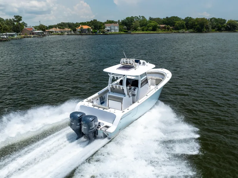 Slide: The Image of 2021 Sportsman Open 302 Center Console boat cruising on a lake. - 4