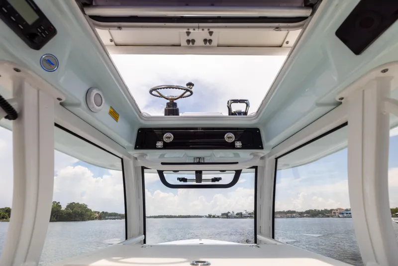 Slide: The Image of Interior view of 2021 Sportsman Open 302 Center Console boat, showcasing helm and water scenery. - 40
