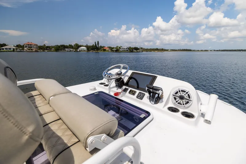 Slide: The Image of 2021 Sportsman Open 302 Center Console boat on calm water, featuring modern controls and seating. - 41