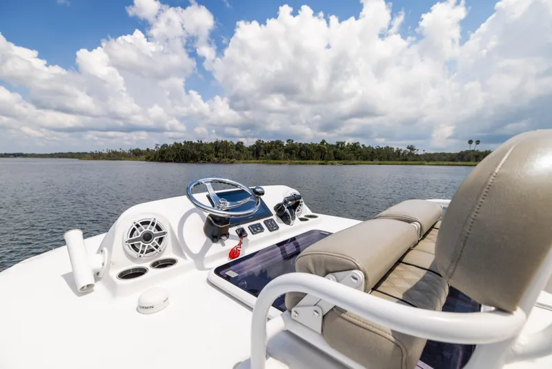 Slide: The Image of 2021 Sportsman Open 302 Center Console boat on a serene lake under a cloudy sky. - 44