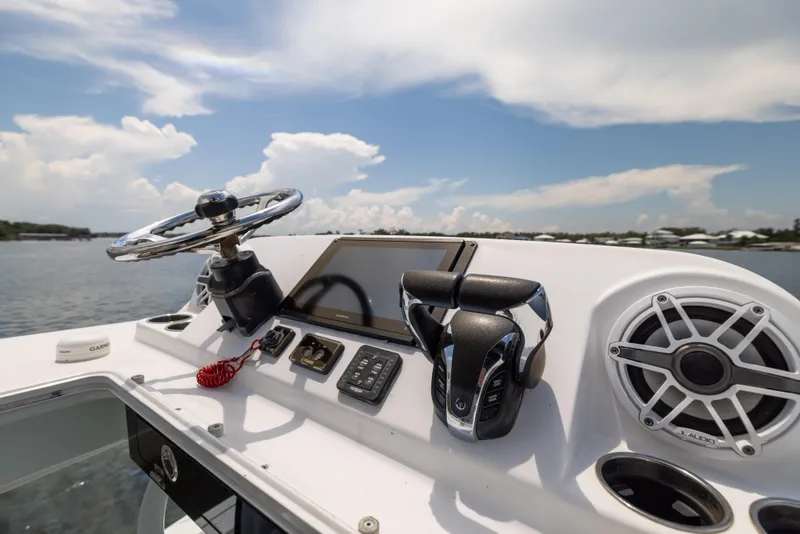 Slide: The Image of 2021 Sportsman Open 302 Center Console boat dashboard with steering wheel and controls. - 48