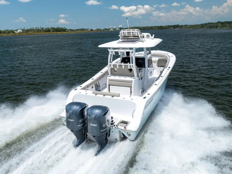 Slide: The Image of 2021 Sportsman Open 302 Center Console boat cruising on water with twin engines. - 6