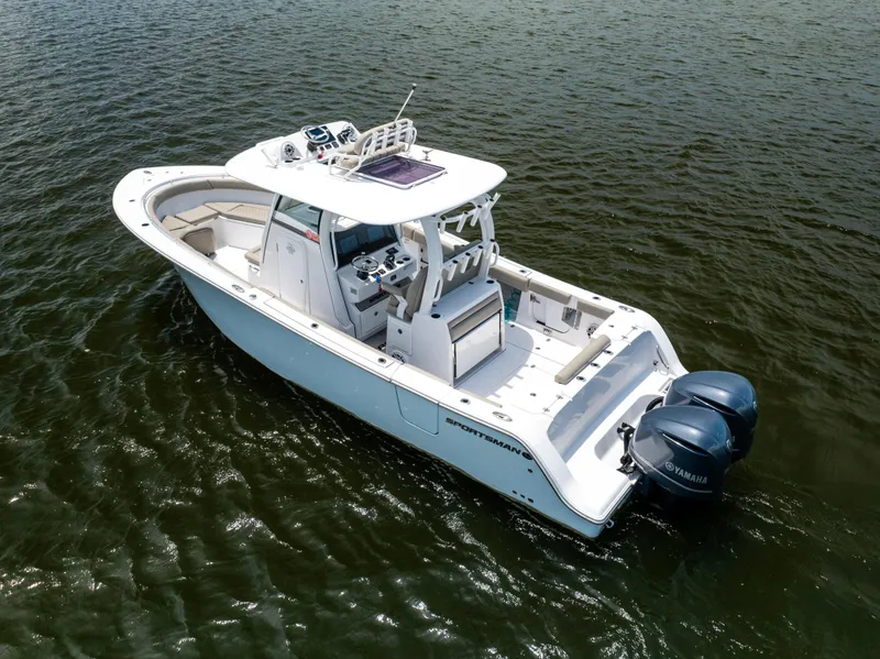 Slide: The Image of 2021 Sportsman Open 302 Center Console boat on water, featuring dual outboard engines. - 9