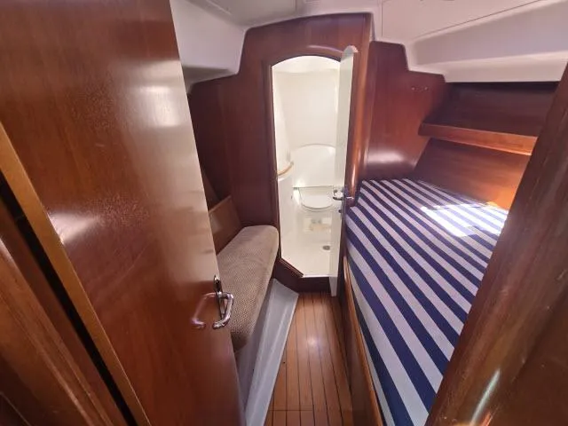 Slide: The Image of Interior of 2003 Beneteau 42CC Oceanis Clipper with striped bedding and wooden finishes. - 11