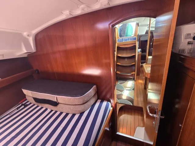 Slide: The Image of Interior of 2003 Beneteau 42CC Oceanis Clipper with wooden finish and striped bedding. - 13