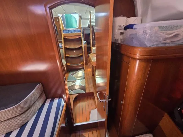 Slide: The Image of Interior of 2003 Beneteau 42CC Oceanis Clipper sailboat with wooden finish and striped cushions. - 14