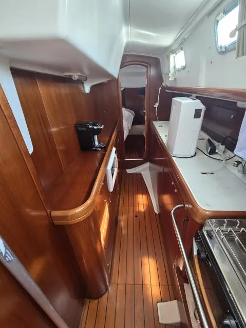 Slide: The Image of Interior of 2003 Beneteau 42CC Oceanis Clipper sailboat with wooden cabinetry and modern appliances. - 16