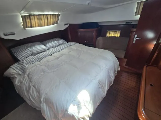 Slide: The Image of Interior of 2003 Beneteau 42CC Oceanis Clipper with cozy bed and wooden furnishings. - 18