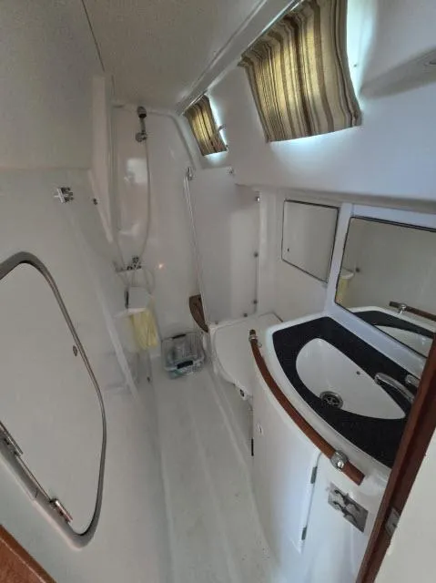Slide: The Image of 2003 Beneteau 42CC Oceanis Clipper bathroom with sink, shower, and porthole windows. - 19