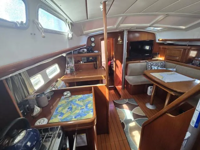 Slide: The Image of Interior of 2003 Beneteau 42CC Oceanis Clipper sailboat, featuring cozy dining and kitchen area. - 2