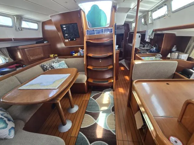Slide: The Image of Interior of 2003 Beneteau 42CC Oceanis Clipper sailboat, featuring cozy seating and wooden finishes. - 5