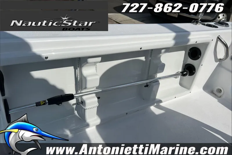 Slide: The Image of 2025 NauticStar 194 Bay boat interior with fishing rod holder, contact details, and logo. - 13