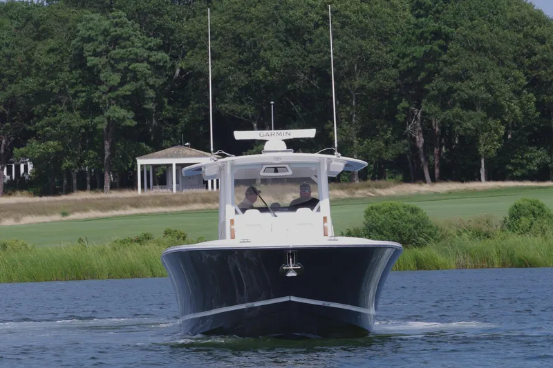 Slide: The Image of 2025 Regulator 37 boat cruising on a lake with lush greenery in the background. - 10