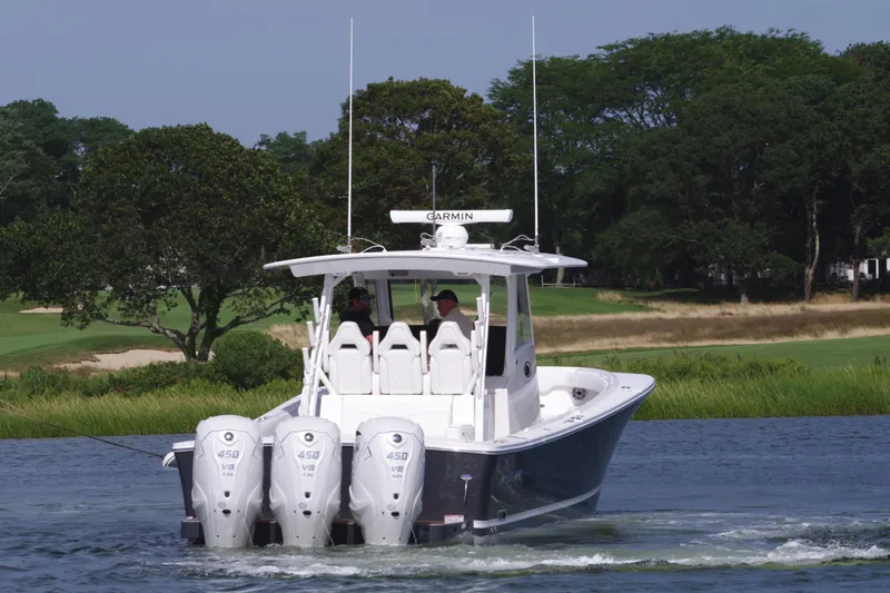 Slide: The Image of 2025 Regulator 37 boat with triple engines cruising on a scenic waterway. - 3