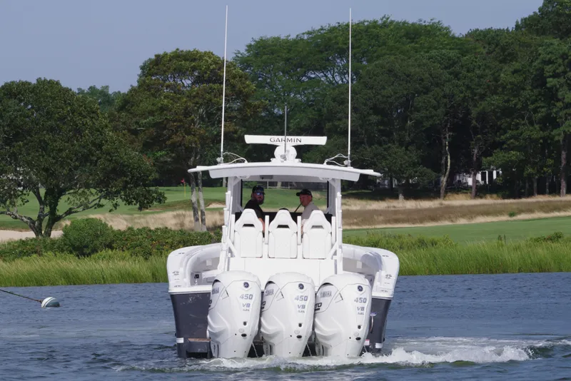 Slide: The Image of 2025 Regulator 37 boat with triple engines cruising on a scenic waterway. - 4