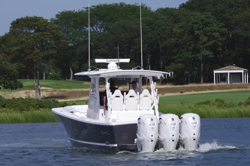 Slide: The Image of 2025 Regulator 37 boat with triple outboard engines on a serene lake. - 5