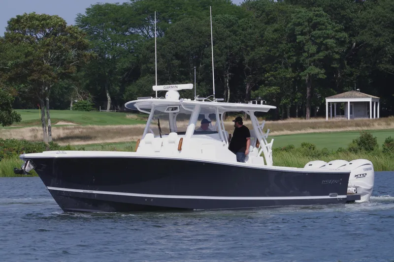 Slide: The Image of 2025 Regulator 37 boat cruising on a serene lake with lush greenery. - 8