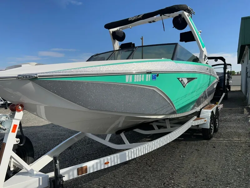 Slide: The Image of 2022 Tigé Z3 boat on trailer, vibrant teal and gray design, sunny day. - 4