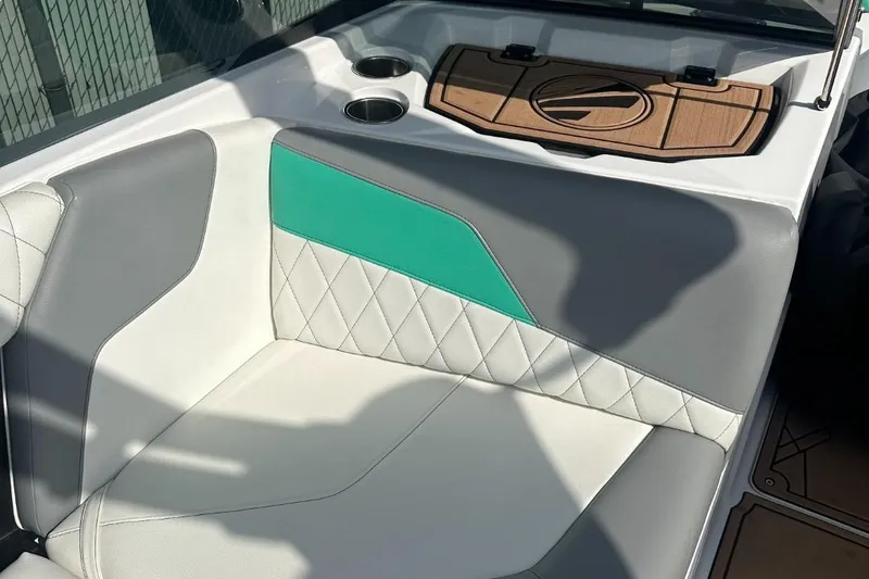 Slide: The Image of 2022 Tigé Z3 boat interior with white, gray, and teal seating, featuring cup holders. - 9