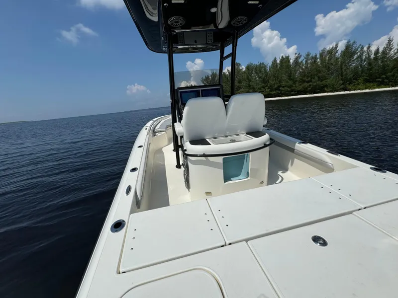 Slide: The Image of 2022 ShearWater 270 Carolina Flare boat on calm water near a forested shoreline. - 15