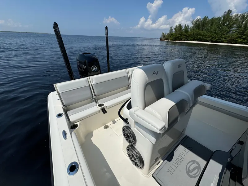 Slide: The Image of 2022 ShearWater 270 Carolina Flare boat on calm water, featuring dual seats and motor. - 19