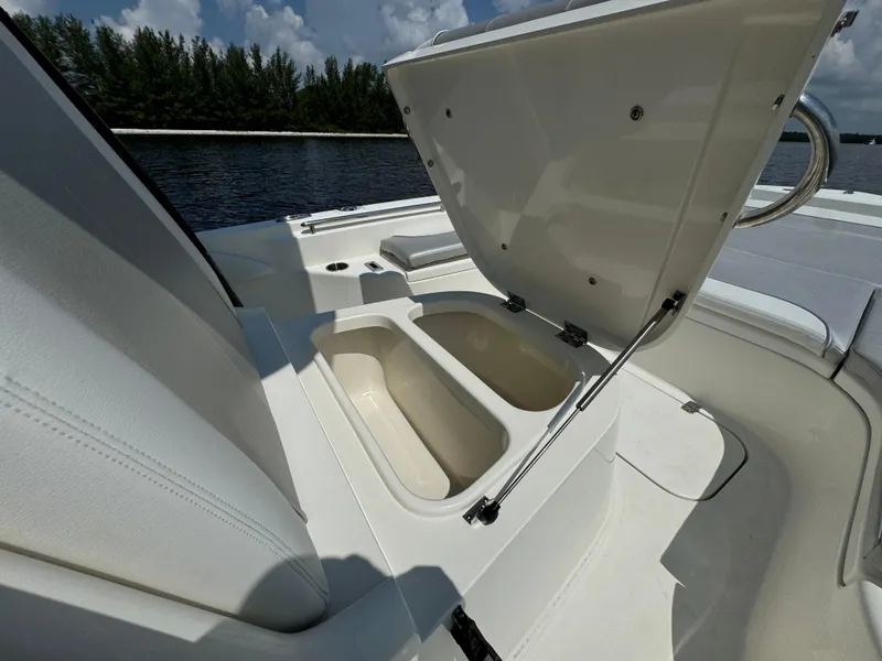 Slide: The Image of 2022 ShearWater 270 Carolina Flare boat with open storage compartment, on calm water. - 9