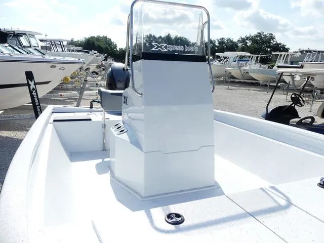 Slide: The Image of 2025 Xpress Boats H190B console with steering wheel and controls, parked outdoors. - 12