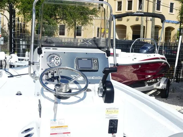 Slide: The Image of 2025 Xpress Boats H190B, sleek design, modern console, outdoor display. - 13