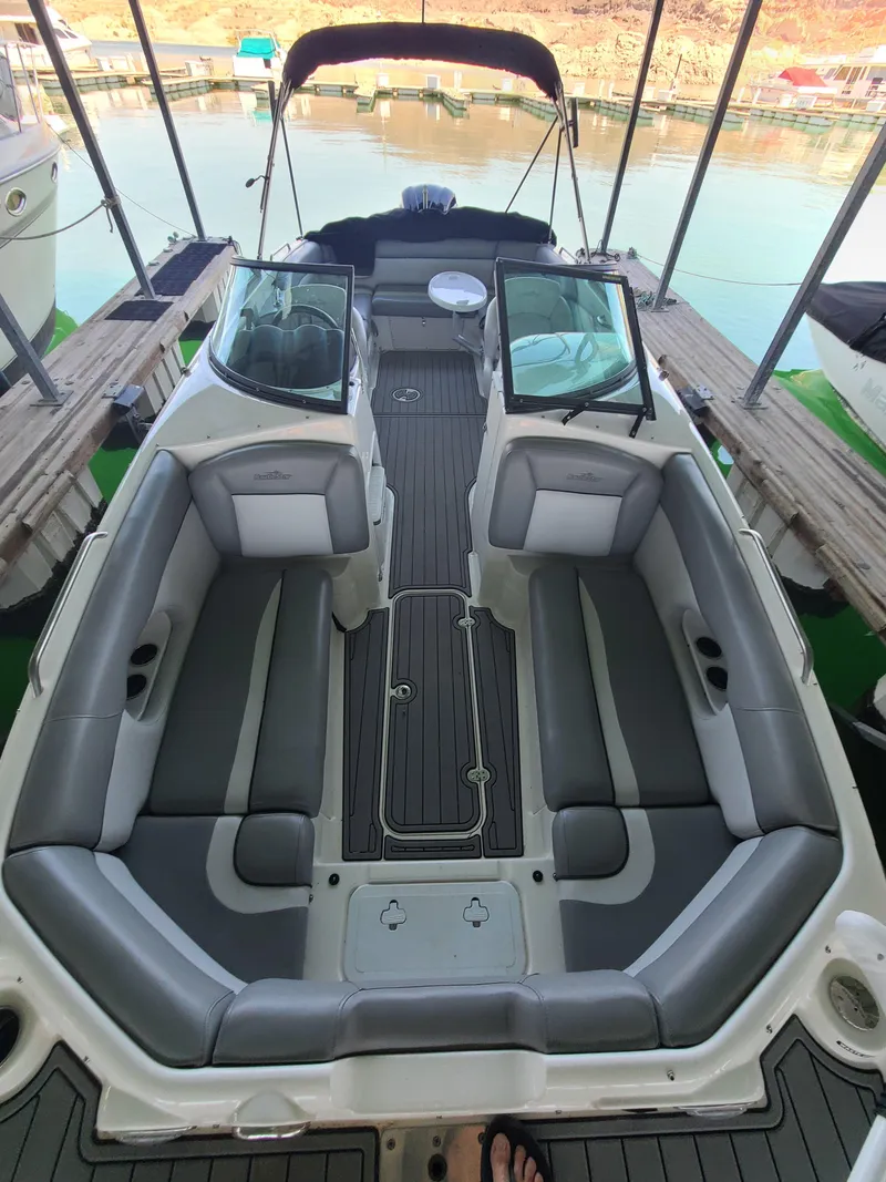 Slide: The Image of 2021 NauticStar 243 DC boat interior with gray seating and open deck layout. - 10